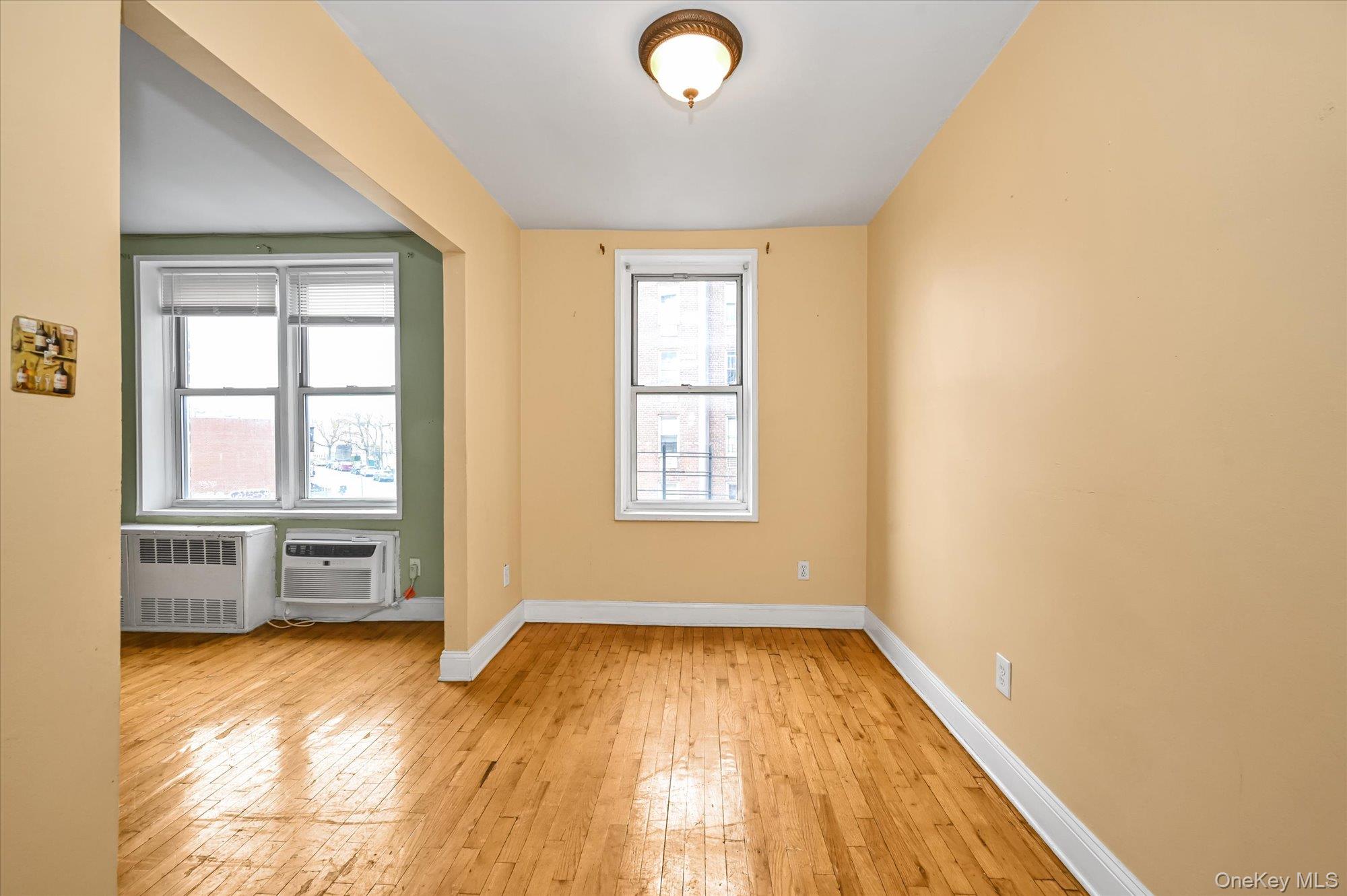 59-30 108th Street, Unit 4P Queens, NY 11368 - Photo 8 of 18 an empty room with a window and wooden floor