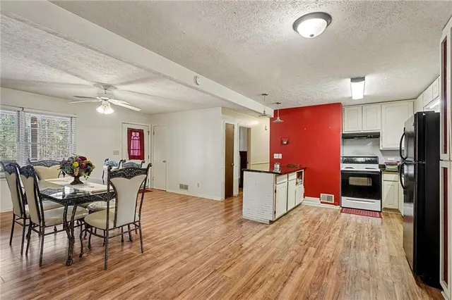 a kitchen with stainless steel appliances kitchen island granite countertop a table chairs stove and refrigerator