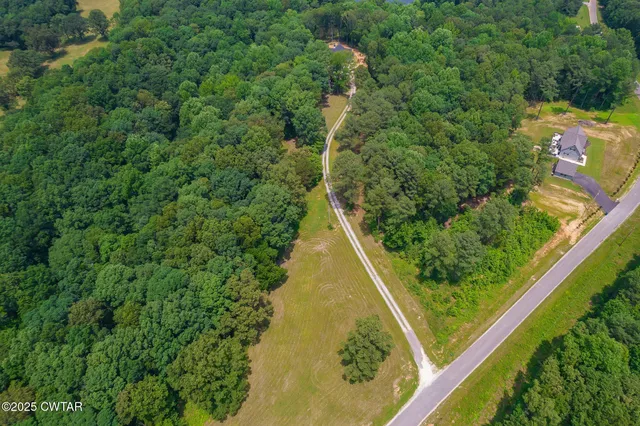 an aerial view of residential house with outdoor space and trees all around