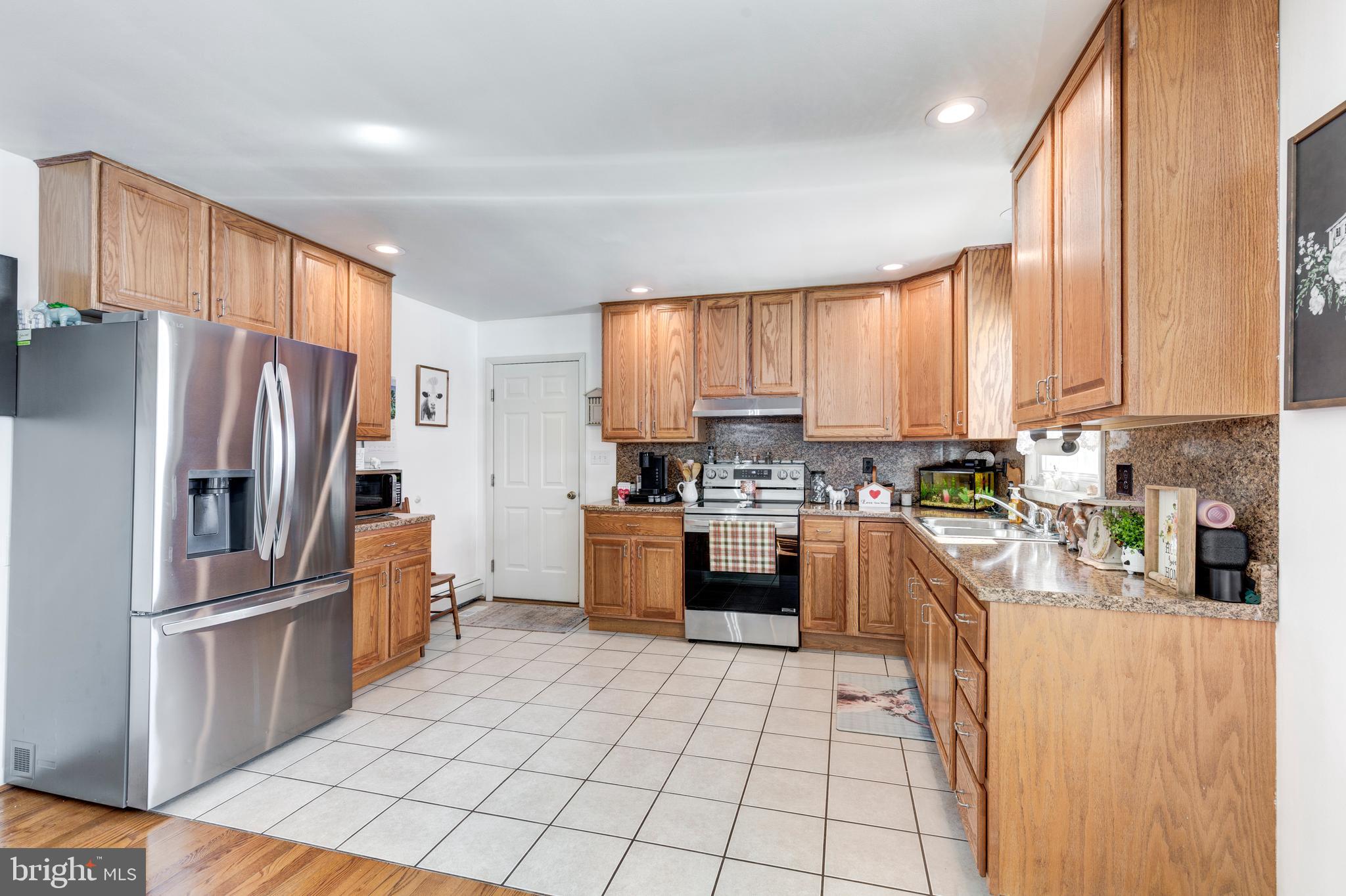 3820 Kump Station Road Taneytown, MD 21787 - Photo 3 of 59 a kitchen with stainless steel appliances granite countertop a refrigerator sink and cabinets