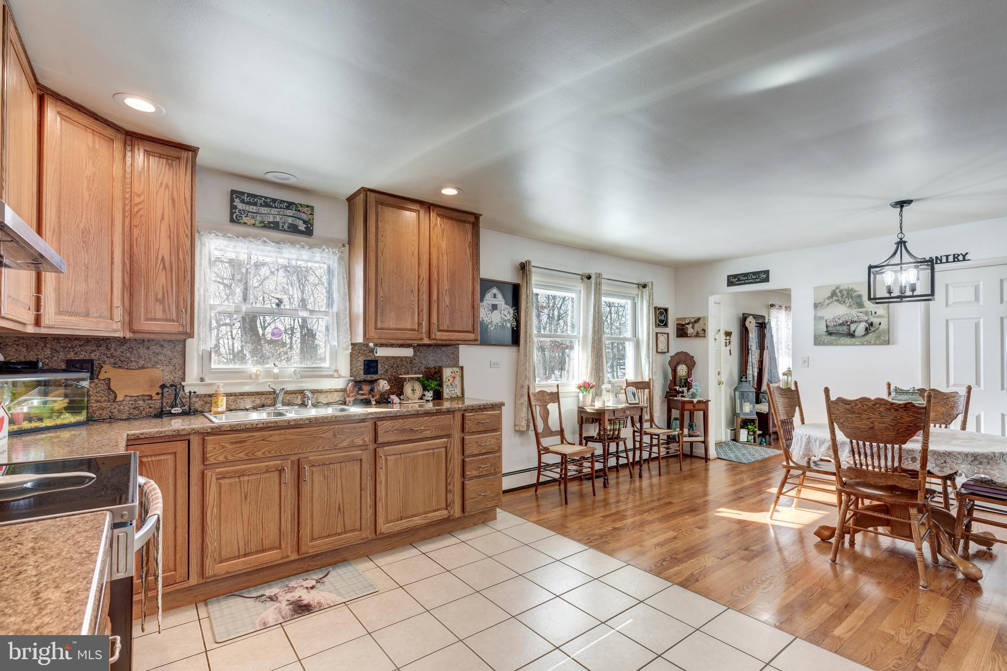 3820 Kump Station Road Taneytown, MD 21787 - Photo 4 of 59 a kitchen with sink cabinets and dining table chair