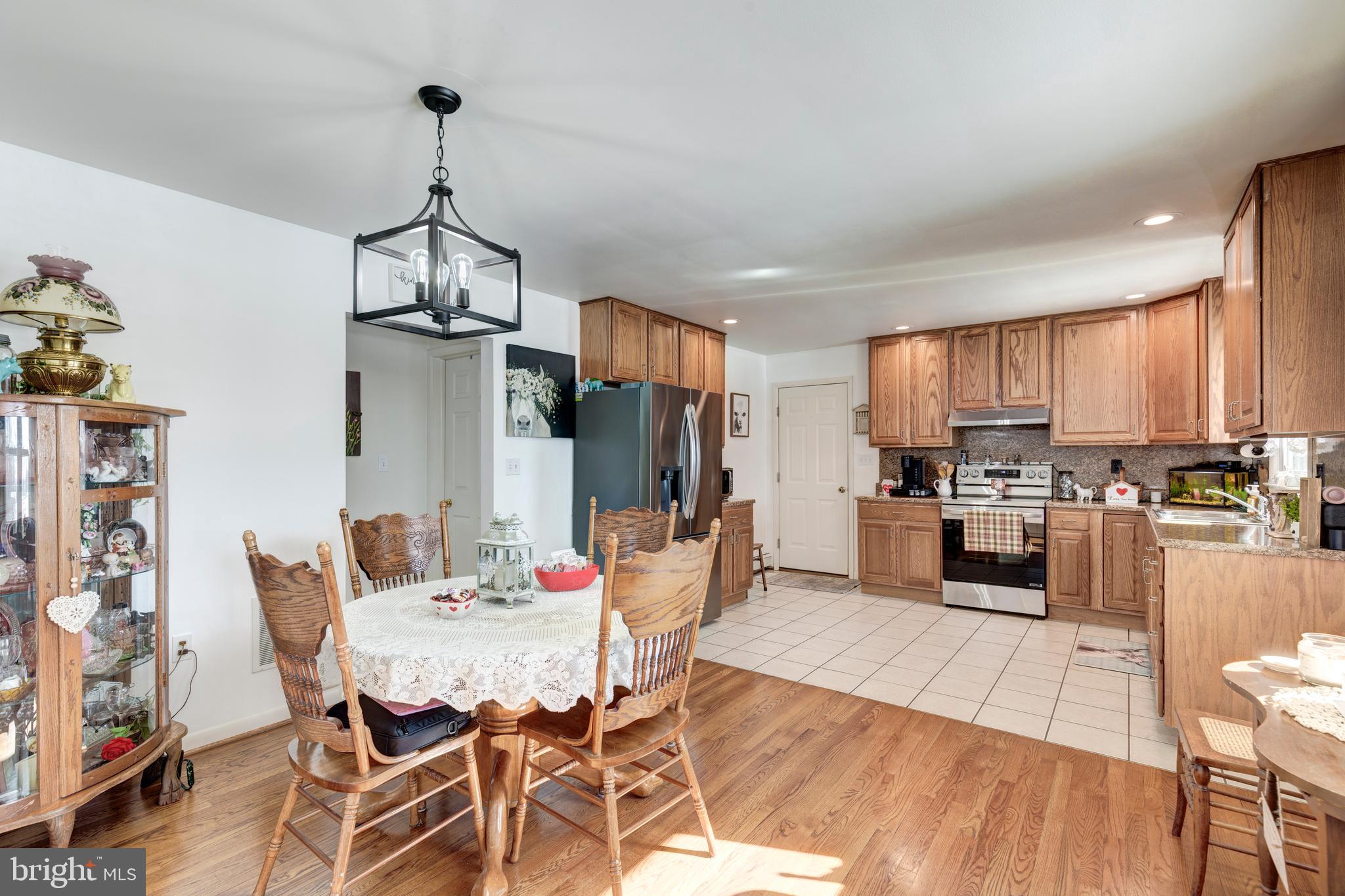 3820 Kump Station Road Taneytown, MD 21787 - Photo 6 of 59 a view of a dining room and livingroom with furniture wooden floor a chandelier