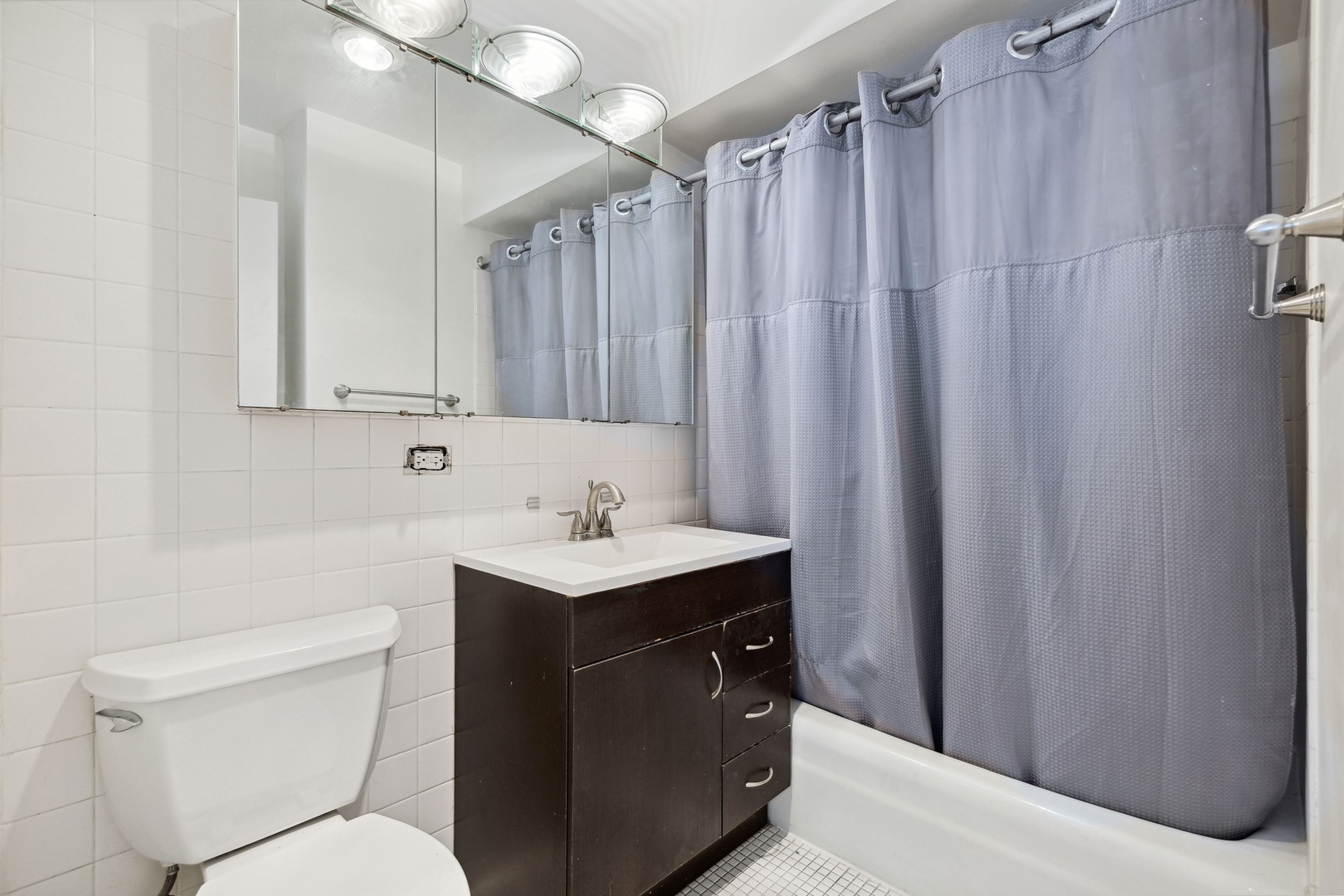 655 West Irving Park Road, Unit 617 Chicago, IL 60613 - Photo 16 of 33 a bathroom with a toilet a sink and a shower curtain