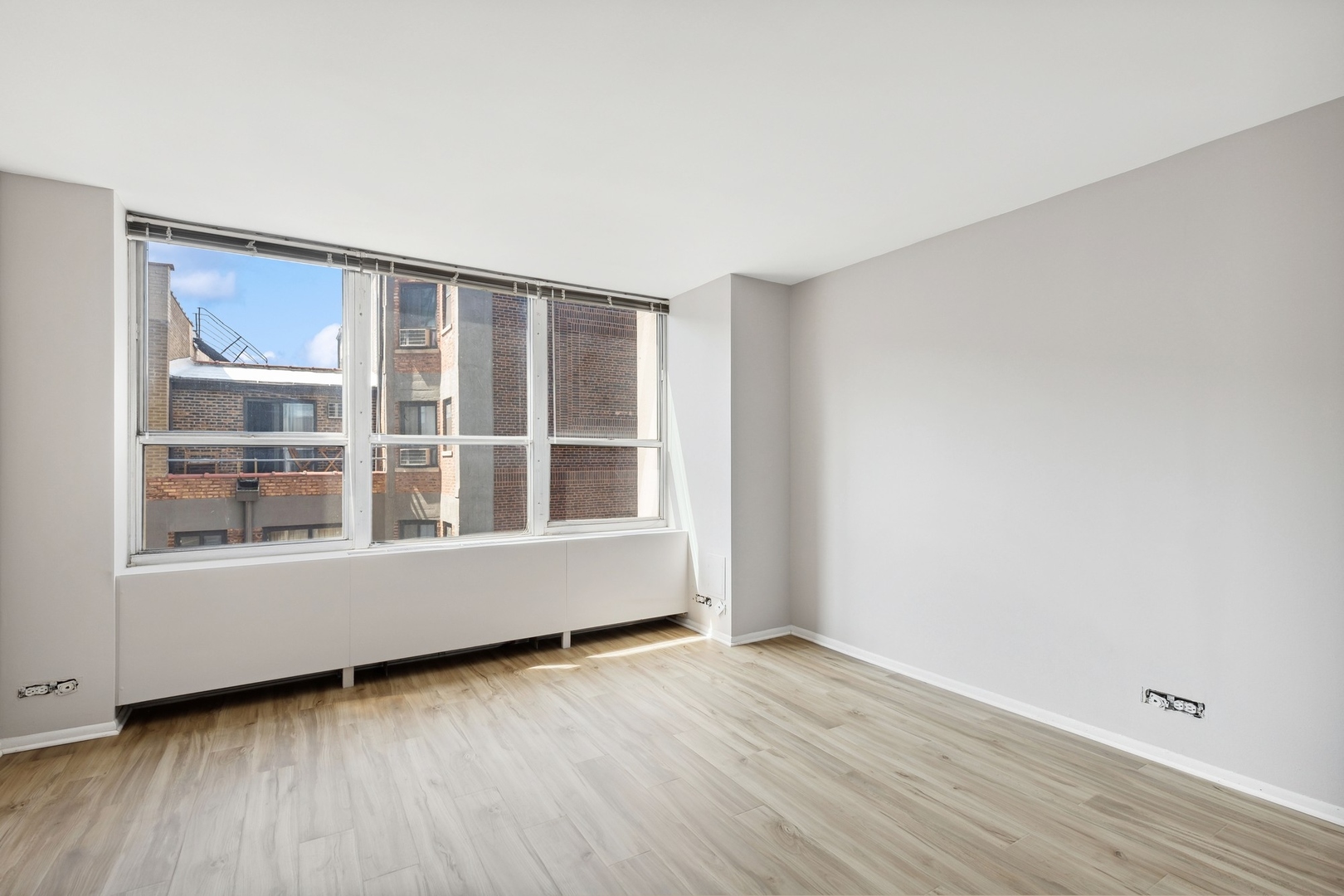 655 West Irving Park Road, Unit 617 Chicago, IL 60613 - Photo 18 of 33 a view of an empty room with wooden floor and a window