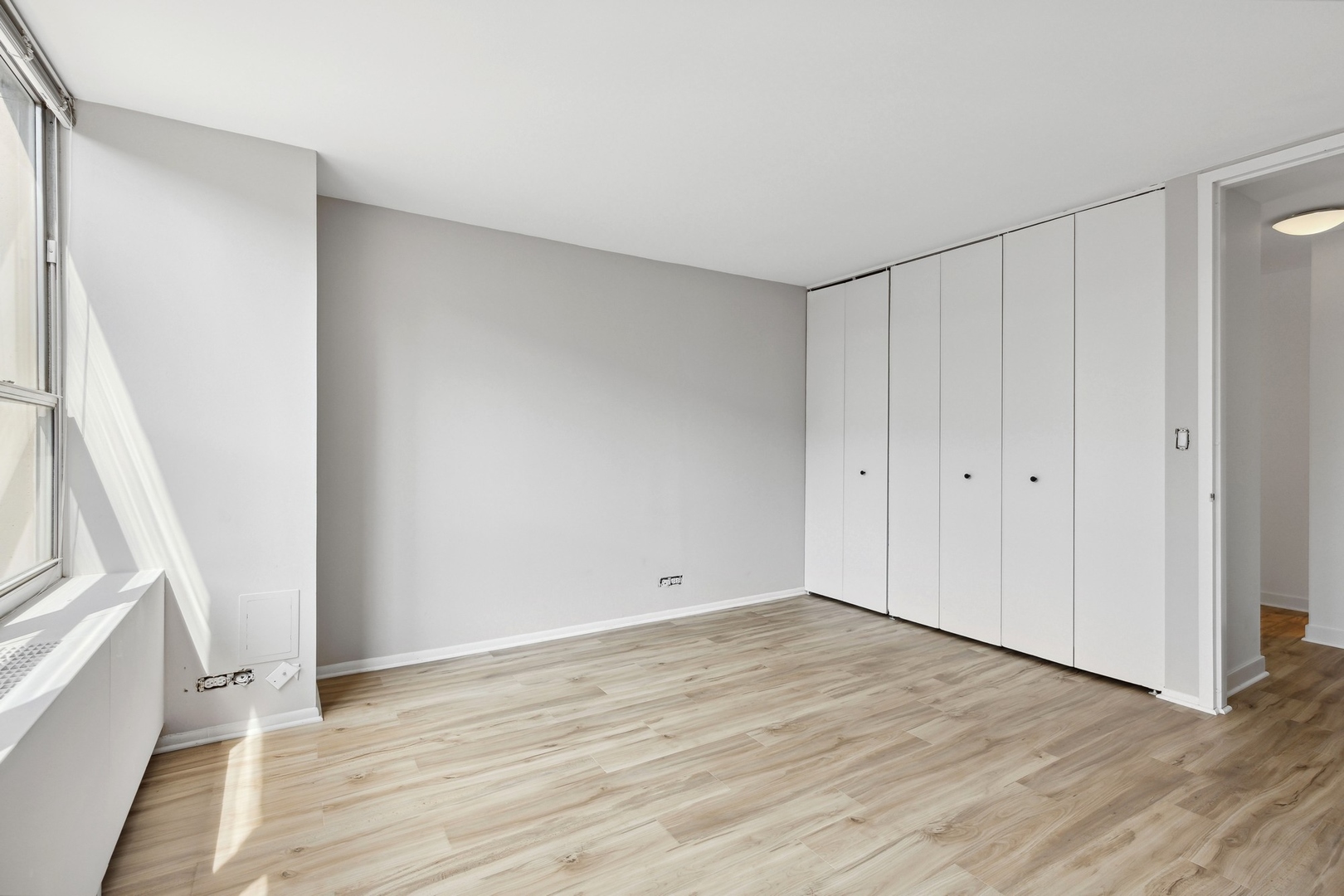 655 West Irving Park Road, Unit 617 Chicago, IL 60613 - Photo 20 of 33 a view of an empty room with wooden floor and a window