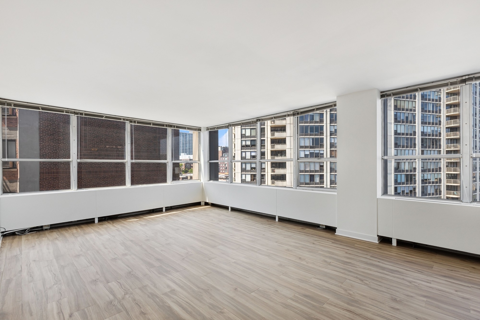 655 West Irving Park Road, Unit 617 Chicago, IL 60613 - Photo 8 of 33 a view of an empty room with wooden floor and windows