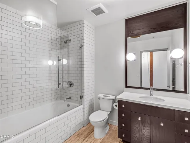a bathroom with a granite countertop toilet sink and mirror