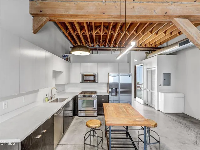 a kitchen with kitchen island a stove a sink and a refrigerator