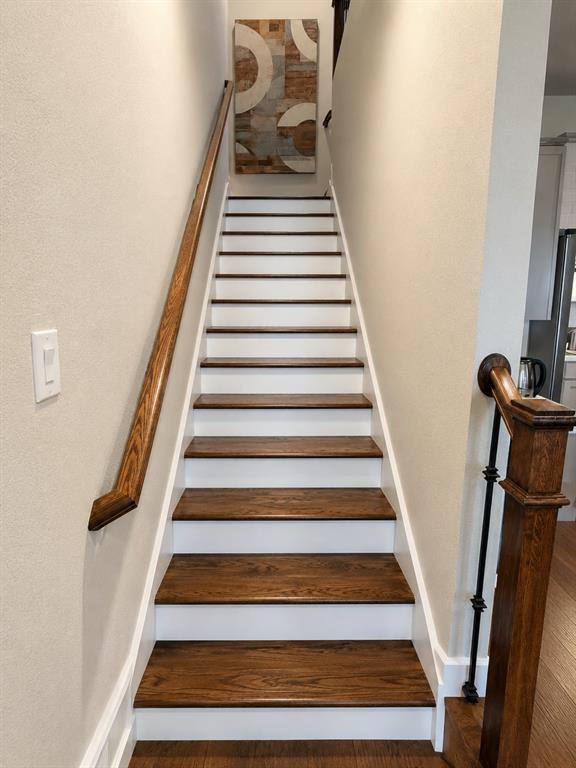 8235 Snapdragon Way Dallas, TX 75252 - Photo 13 of 29 Staircase featuring wood-finish treads, white risers, and a coordinating wood-finish handrail