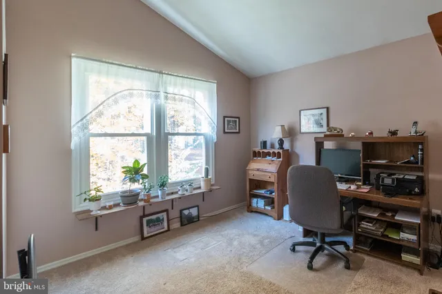 a view of a workspace with furniture and a window