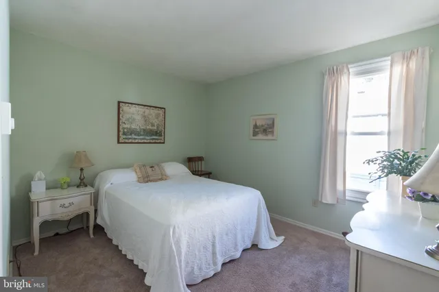 a bedroom with a bed and a potted plant