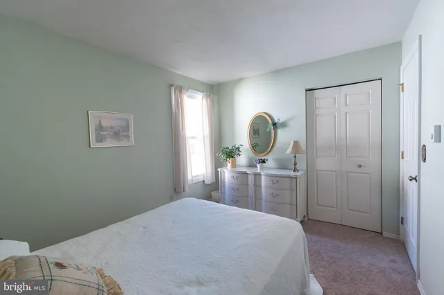a bedroom with a bed and a mirror on dresser