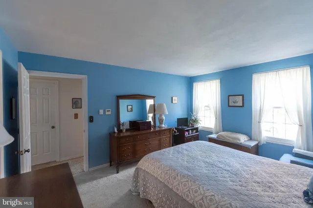 a bedroom with a bed and dresser with mirror