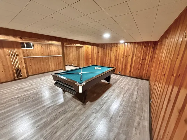 a room with wooden floor and pool table