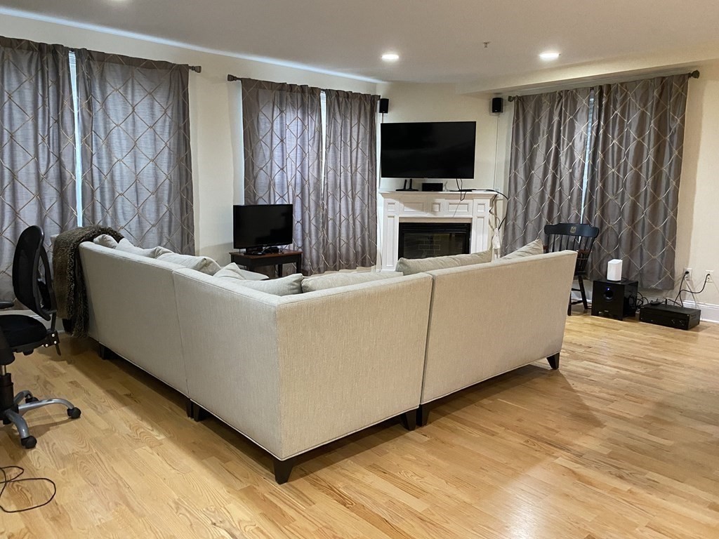 a living room with furniture a fireplace and a flat screen tv