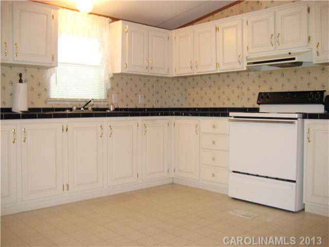 3915 Berry Hill Road Edgemoor, SC 29712 - Photo 7 of 16 a kitchen with granite countertop white cabinets and white appliances