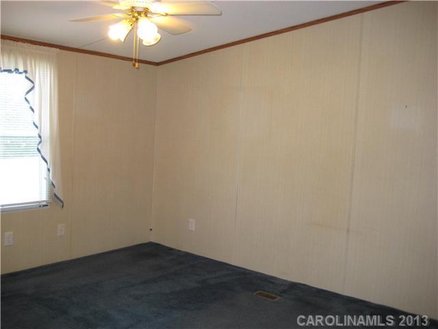 3915 Berry Hill Road Edgemoor, SC 29712 - Photo 9 of 16 an empty room with a chandelier fan and wooden floor
