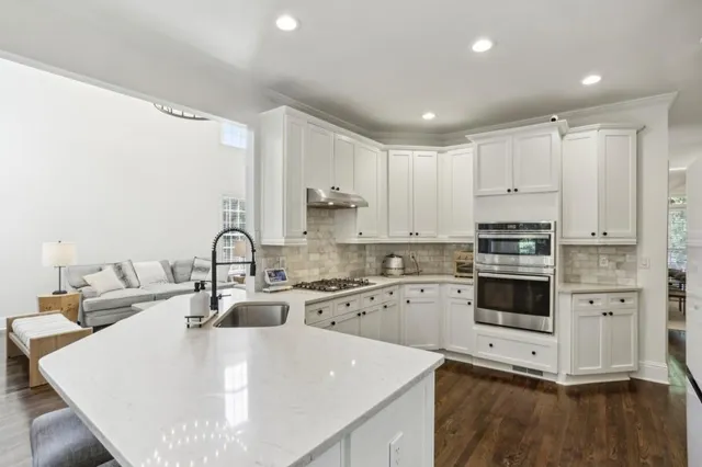 a kitchen with a sink a stove top oven and white kitchen