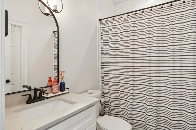 a bathroom with a sink a toilet and a mirror