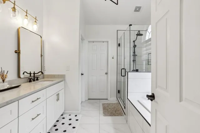 a spacious bathroom with a granite countertop sink mirror and shower