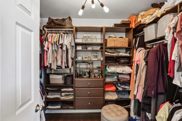 a view of walk in closet with clothes and shoes