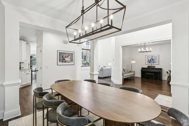 a view of a dining room and livingroom with furniture wooden floor a chandelier