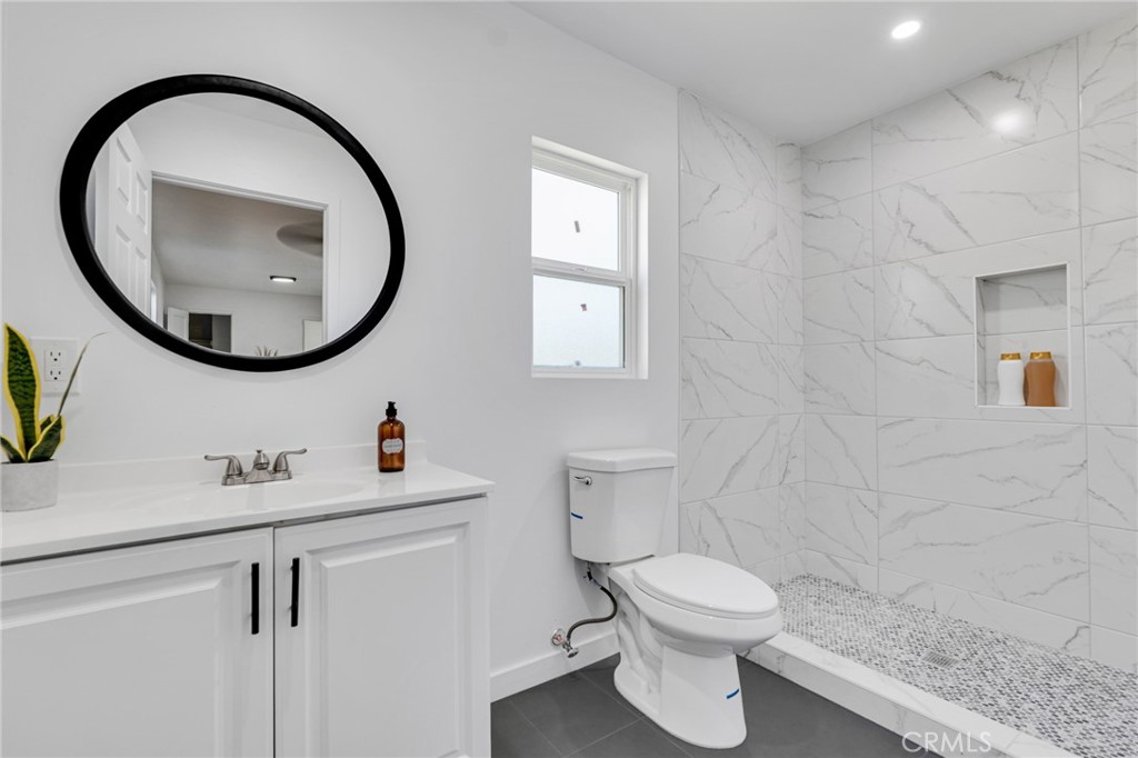 2124 East Oris Street Compton, CA 90222 - Photo 9 of 20 a bathroom with a toilet a sink and a mirror