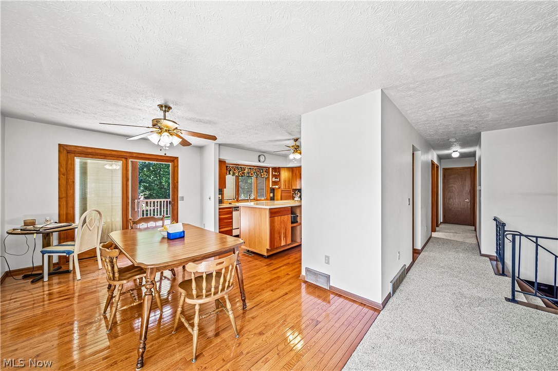 3010 Narrows Road Perry, OH 44081 - Photo 7 of 42 Dining room with ceiling fan, featuring light hardwood floors and sliding glass doors leading out onto deck.