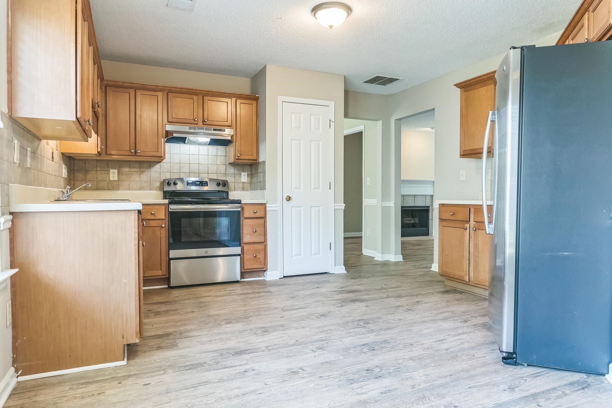 5368 Milton Ridge Drive Arlington, TN 38002 - Photo 6 of 15 Kitchen featuring light wood-style flooring, under cabinet range hood, visible vents, and stainless steel appliances
