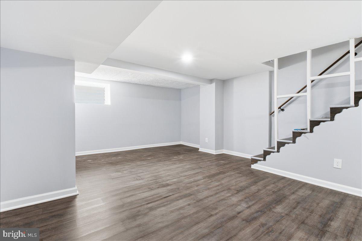 1231 North Potomac Street Baltimore, MD 21213 - Photo 23 of 25 a view of an empty room with wooden floor and stairs