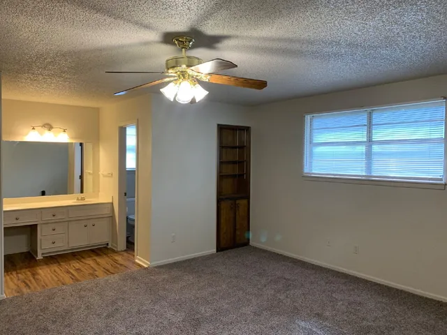 a view of a livingroom with a chandelier fan and a bathroom