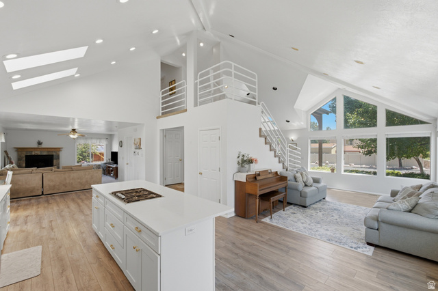 5788 Walden Ridge Drive Murray, UT 84123 - Photo 3 of 29 Spacious interior featuring a vaulted ceiling with skylights, wood-finish flooring, and a contemporary open-tread staircase with white railings