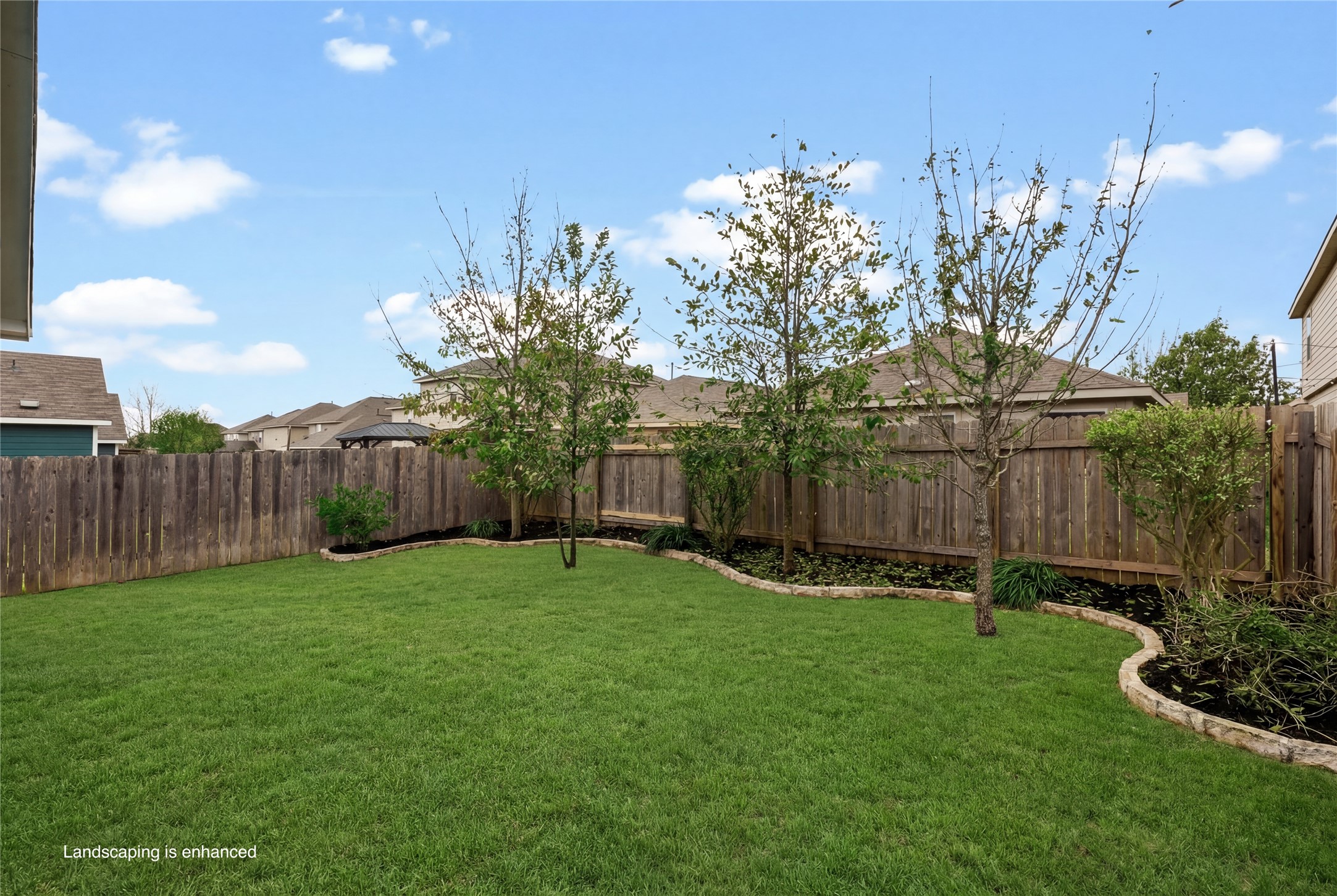 7101 Spirit Hill Road Austin, TX 78744 - Photo 29 of 40 Updated landscaping with limestone border adds a custom look in the backyard! Image includes virtual landscaping enhancement.