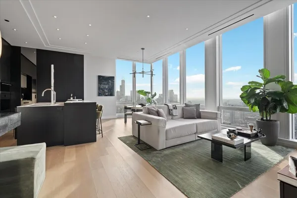 a living room with furniture potted plant and a large window