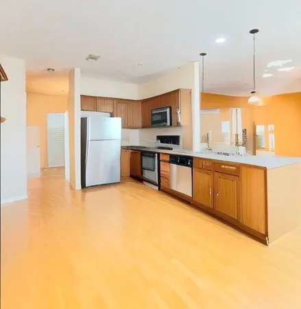 a view of a kitchen with a sink and dishwasher a stove top oven with a large window