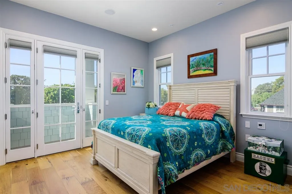 261 E Avenue Coronado, CA 92118 - Photo 15 of 25 a bedroom with a bed a dresser next to a window