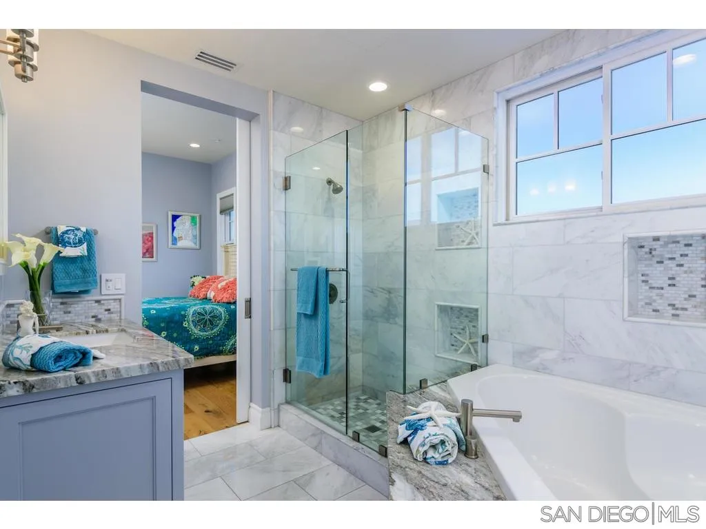 261 E Avenue Coronado, CA 92118 - Photo 16 of 25 a bathroom with a granite countertop sink a mirror and shower