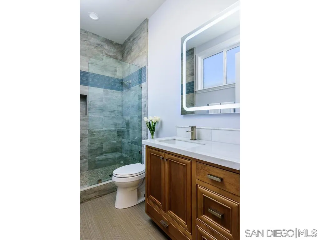 261 E Avenue Coronado, CA 92118 - Photo 19 of 25 a bathroom with a sink a toilet and a mirror