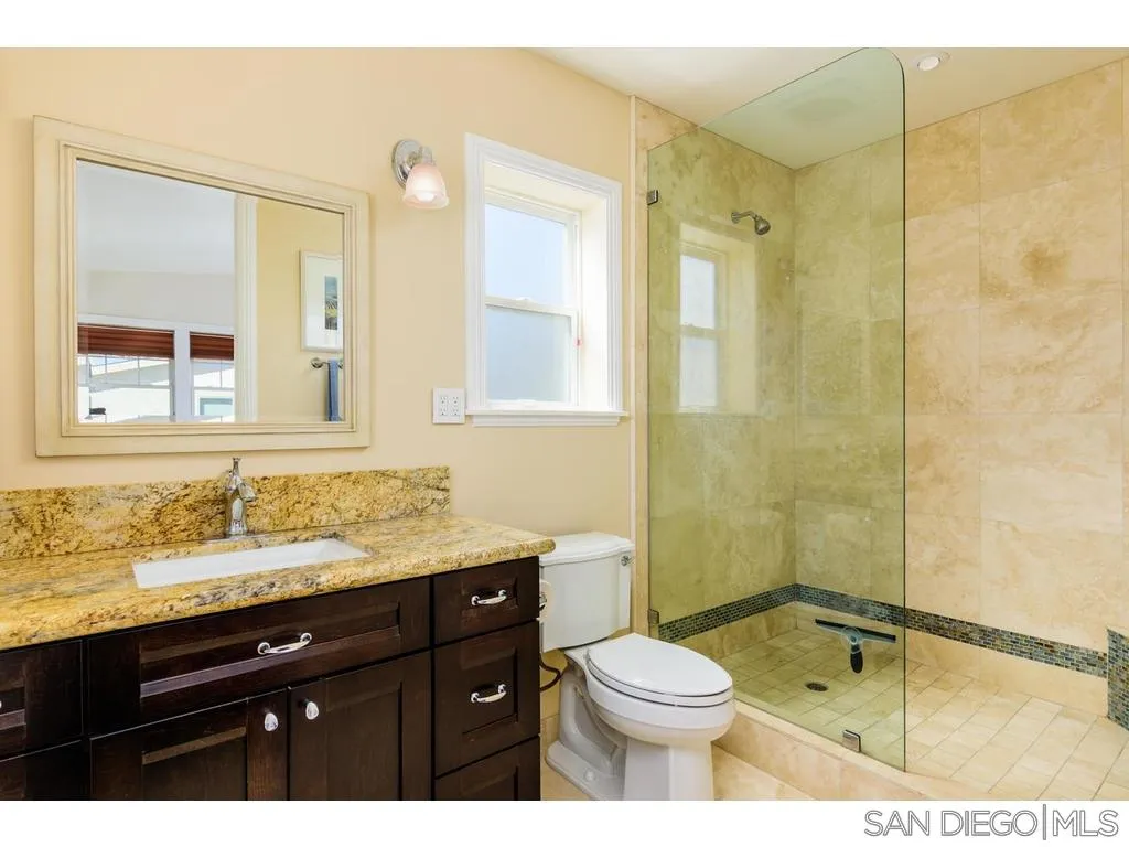 261 E Avenue Coronado, CA 92118 - Photo 23 of 25 a bathroom with a granite countertop sink toilet and shower