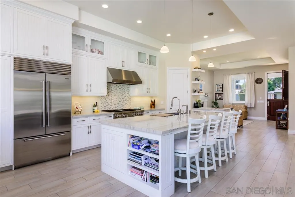 261 E Avenue Coronado, CA 92118 - Photo 5 of 25 a kitchen with stainless steel appliances a dining table chairs stove and refrigerator