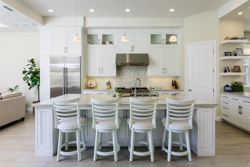 261 E Avenue Coronado, CA 92118 - Photo 6 of 25 a kitchen with stainless steel appliances kitchen island granite countertop a table and chairs