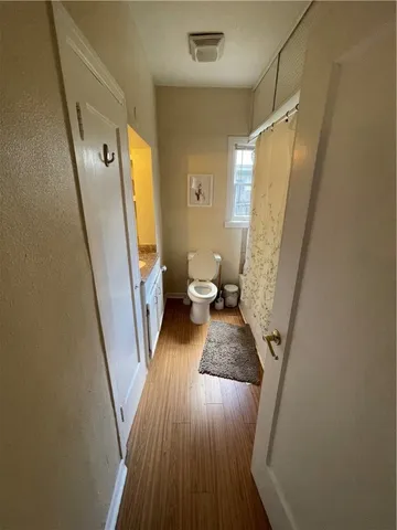 a view of a hallway with furniture and wooden floor