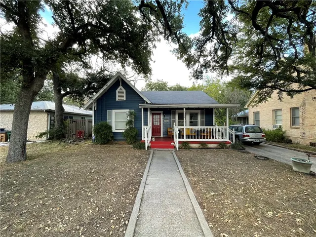 a front view of a house with a yard and fence