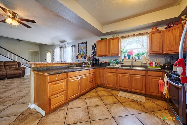 a kitchen with stainless steel appliances granite countertop a sink stove and cabinets