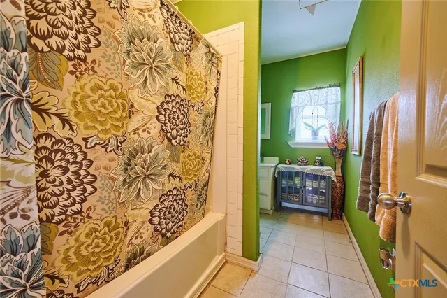 a bathroom with a tub sink and mirror