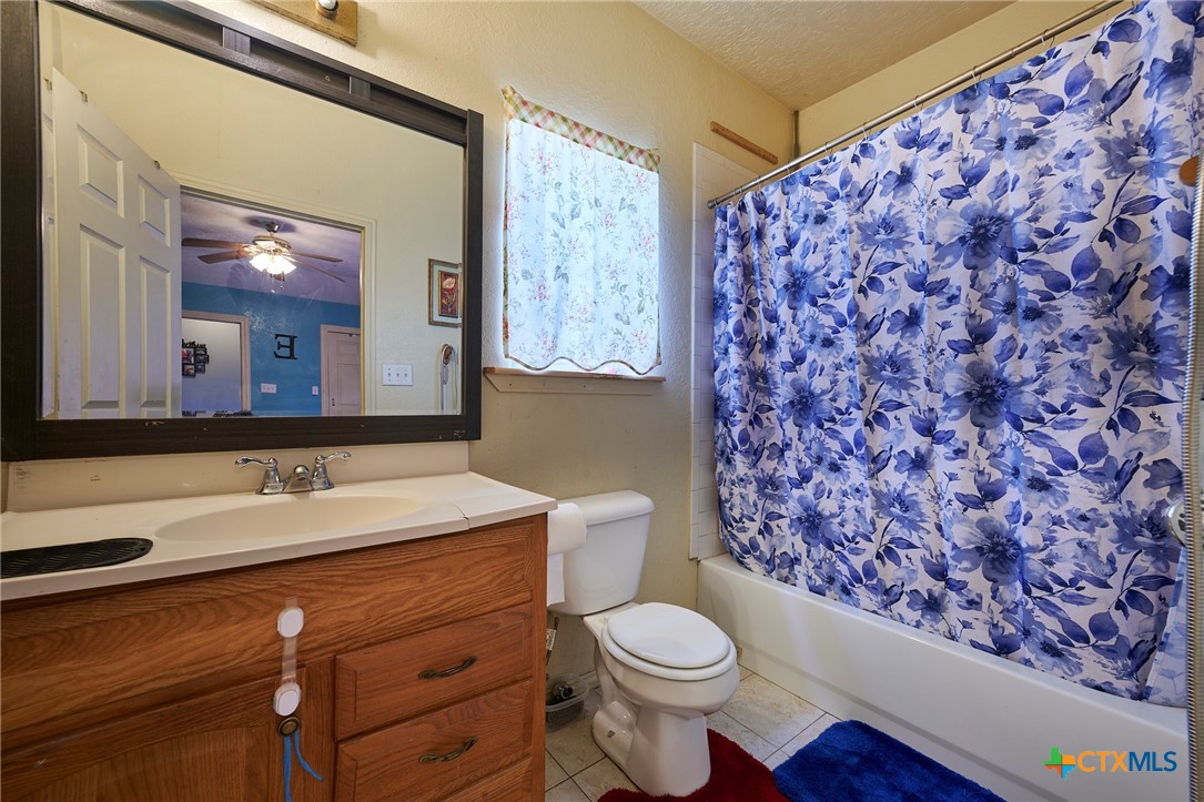 1085 Garrett Trail Maxwell, TX 78656 - Photo 22 of 40 a bathroom with a granite countertop sink mirror vanity and toilet