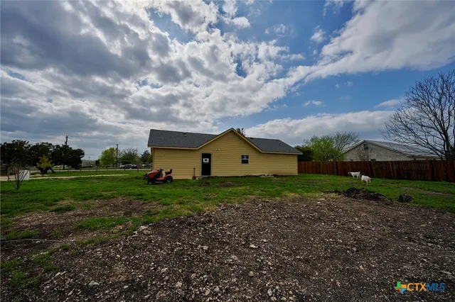 a view of a big house with a big yard and large tree