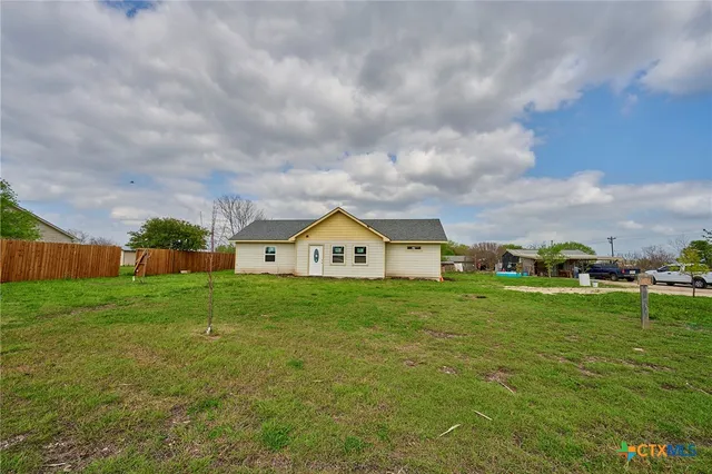 a view of a big yard with a house in the background