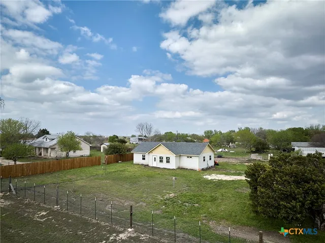 a view of a big house with a big yard and large tree