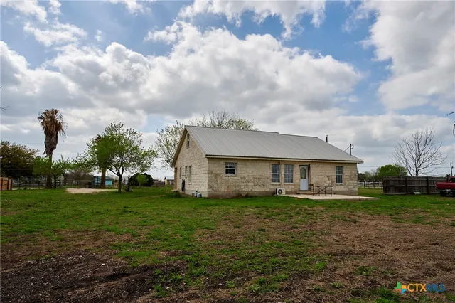 a view of a house with a big yard and large trees